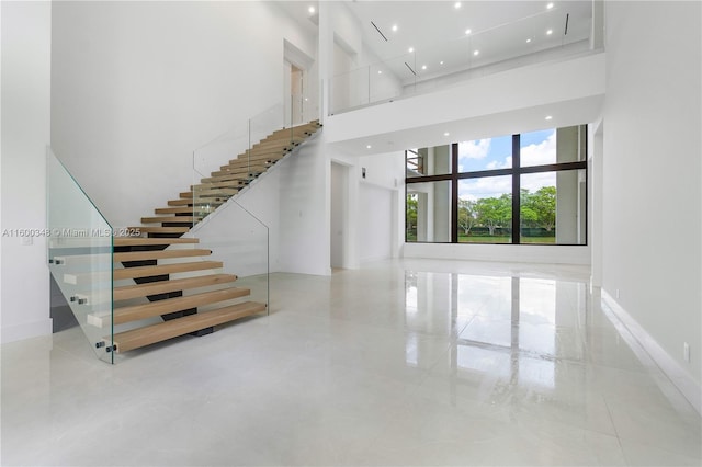 stairs with a high ceiling and baseboards