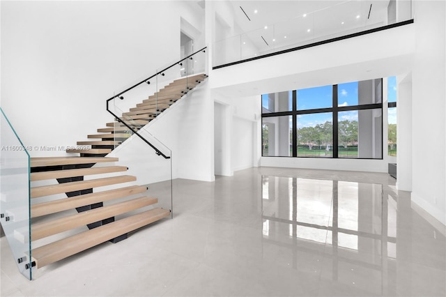 staircase featuring a towering ceiling