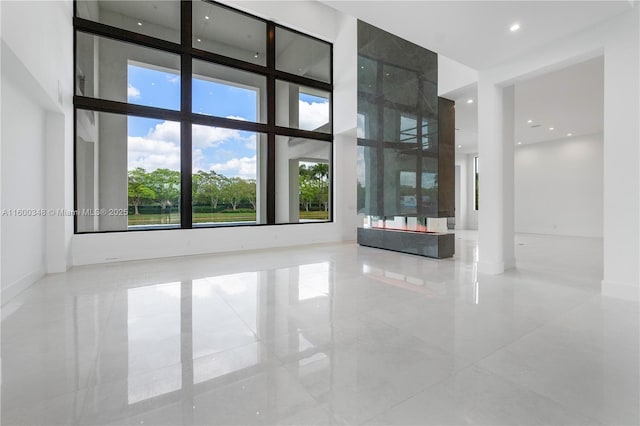 spare room featuring recessed lighting, a high ceiling, and marble finish floor