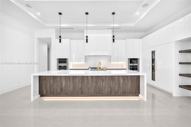 kitchen with modern cabinets and a raised ceiling