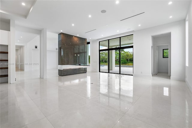 spare room featuring recessed lighting, baseboards, marble finish floor, and floor to ceiling windows