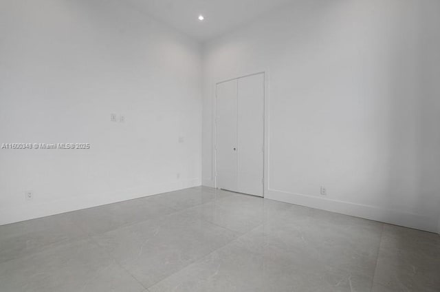 empty room featuring recessed lighting and baseboards