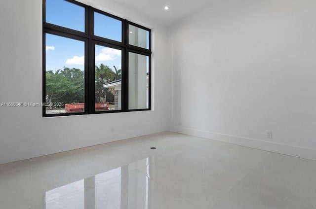 unfurnished room featuring recessed lighting and baseboards