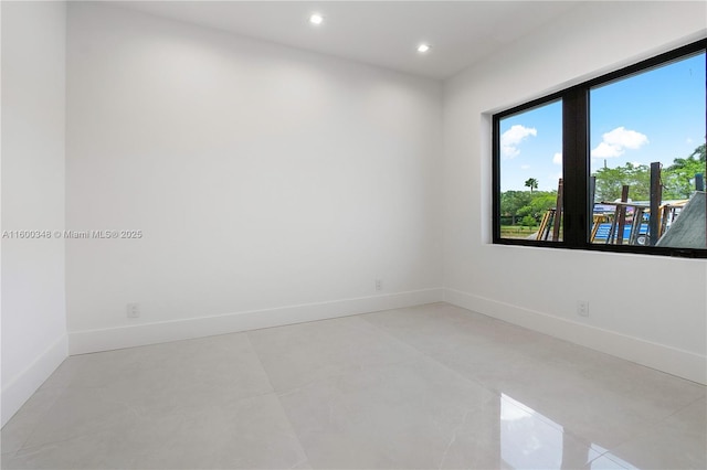 empty room with recessed lighting and baseboards