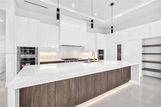 kitchen with white cabinets, double oven, modern cabinets, and a sink