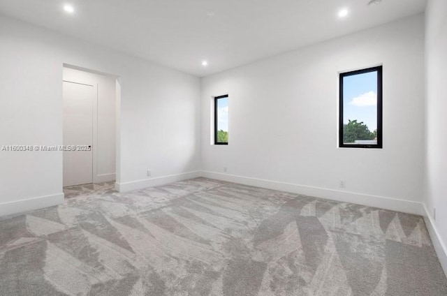 spare room featuring carpet flooring, recessed lighting, and baseboards