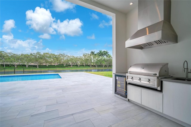 view of swimming pool featuring a sink, a patio, area for grilling, and an outdoor kitchen