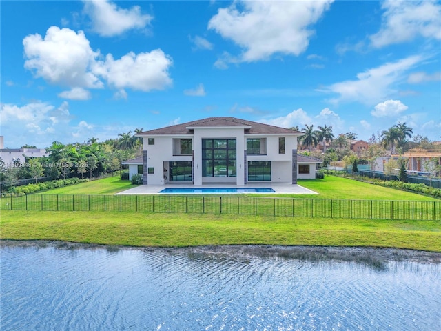 rear view of property featuring a patio, a yard, a fenced backyard, stucco siding, and a water view