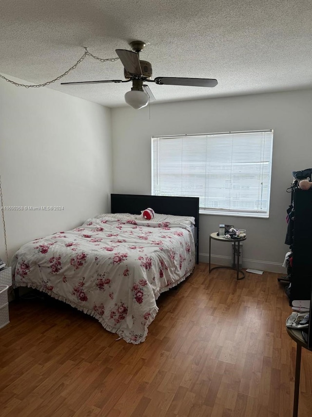 bedroom featuring a textured ceiling, ceiling fan, and hardwood / wood-style floors