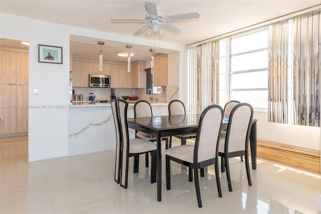 tiled dining room with sink and ceiling fan