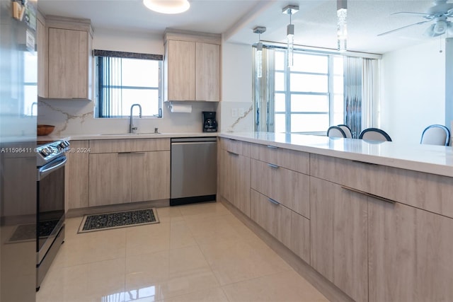 kitchen with light brown cabinetry, sink, decorative backsplash, and appliances with stainless steel finishes