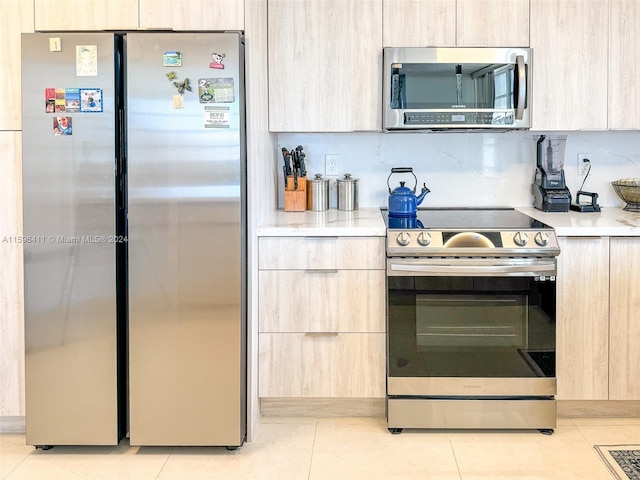 kitchen featuring appliances with stainless steel finishes, light brown cabinetry, and light tile patterned floors