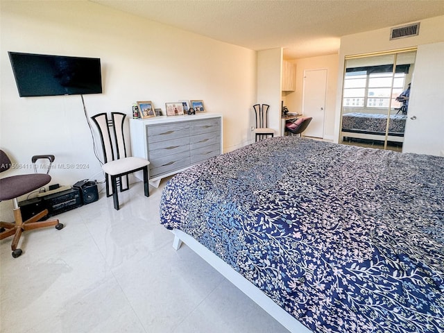 bedroom with a textured ceiling and a closet