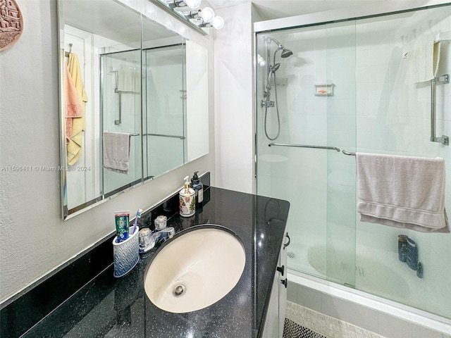 bathroom featuring enclosed tub / shower combo and vanity