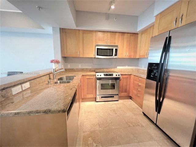 kitchen with light stone counters, stainless steel appliances, sink, and light brown cabinets