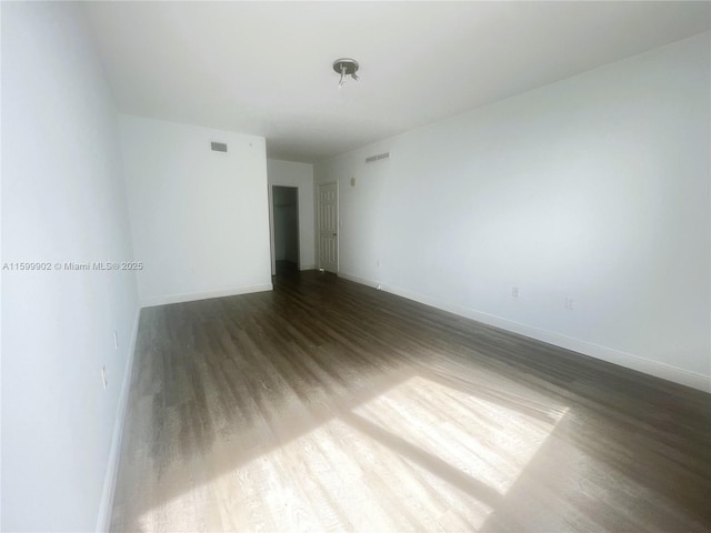 spare room featuring dark hardwood / wood-style flooring