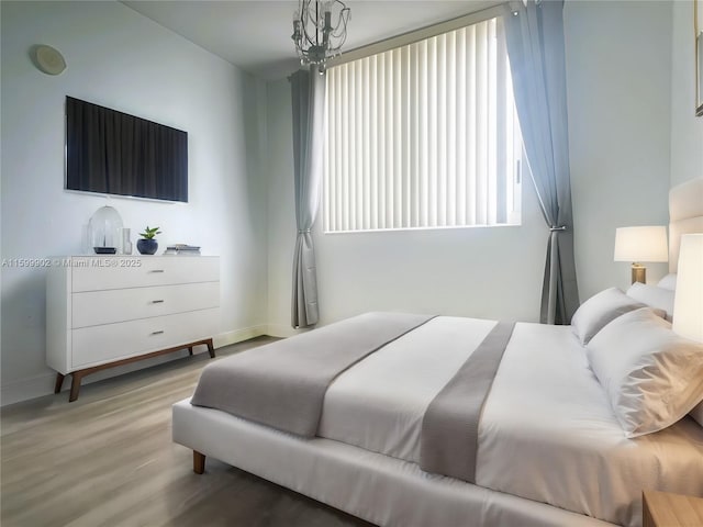 bedroom featuring a chandelier and light hardwood / wood-style flooring