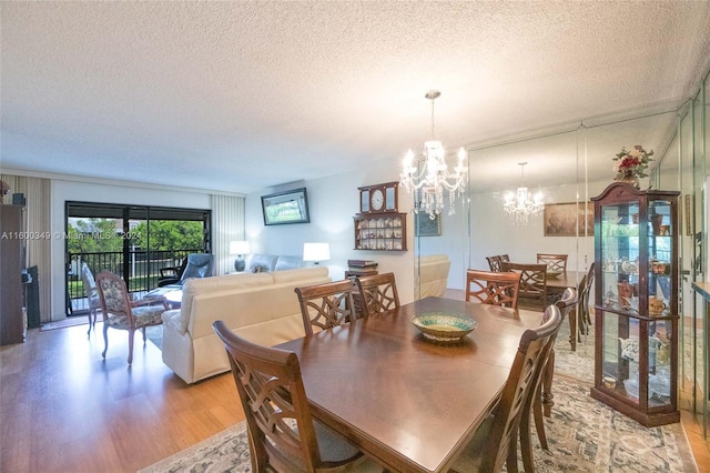 dining space with a textured ceiling, hardwood / wood-style flooring, and a chandelier