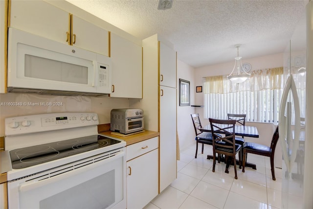 kitchen featuring decorative light fixtures, a textured ceiling, white appliances, and light tile floors