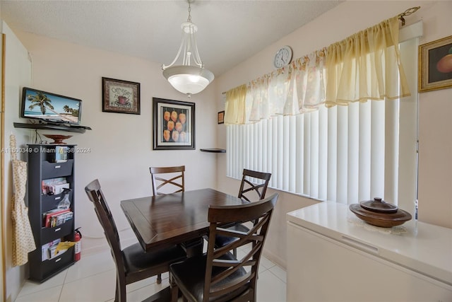 dining room with a textured ceiling and light tile flooring