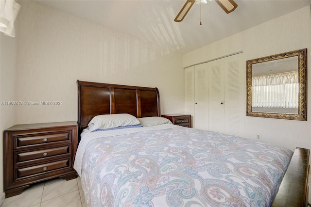 bedroom with ceiling fan, a closet, and light tile flooring