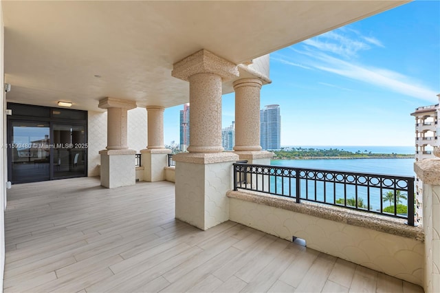 view of patio featuring a balcony and a water view