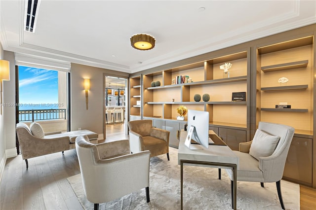 living area with a water view, ornamental molding, and light hardwood / wood-style flooring