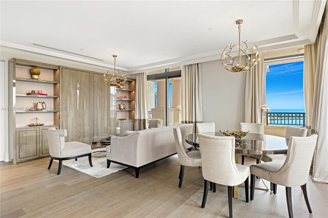 dining area with ornamental molding, a notable chandelier, and light hardwood / wood-style floors