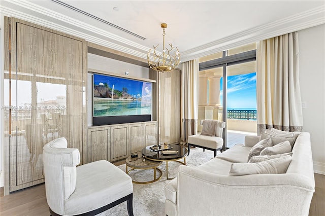 living area with crown molding, wood finished floors, and a chandelier