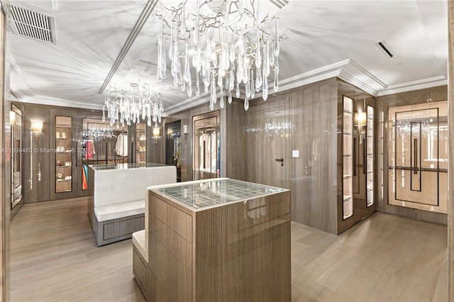 walk in closet featuring light wood finished floors, visible vents, and a notable chandelier