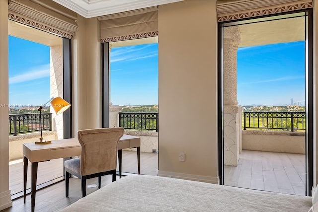 bedroom featuring light hardwood / wood-style flooring, multiple windows, and ornamental molding