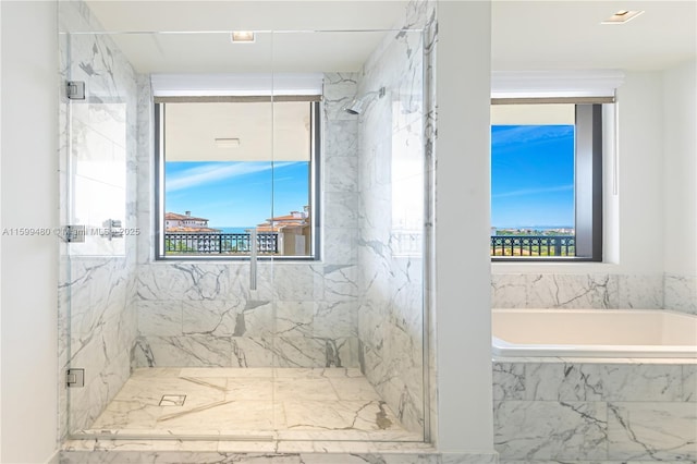 full bath featuring a garden tub and a marble finish shower