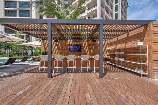 wooden deck with an outdoor bar and a pergola