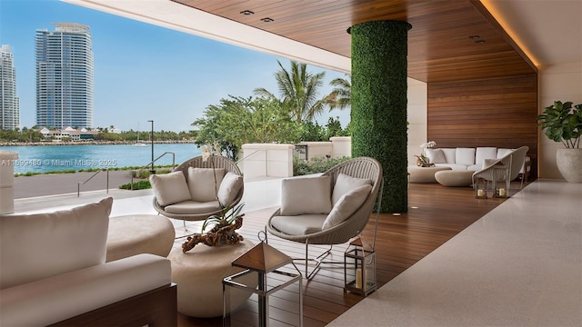 view of patio with an outdoor living space, a water view, and a city view