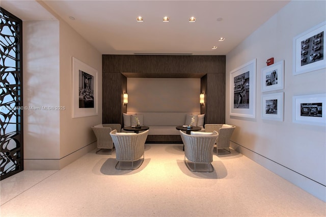living area with recessed lighting and an accent wall