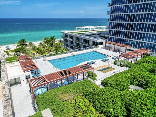 view of pool featuring a beach view, a water view, and a pergola