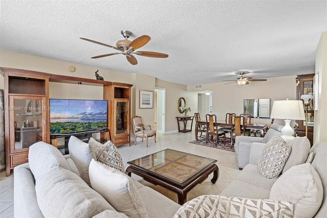 living room featuring a textured ceiling, ceiling fan, and light tile floors