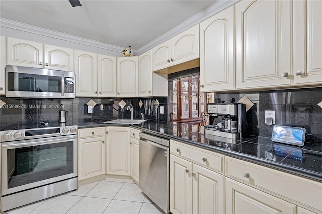 kitchen with stainless steel appliances, light tile floors, sink, and backsplash