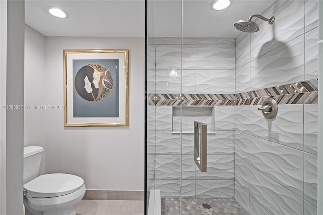 bathroom featuring a tile shower, tile flooring, and toilet