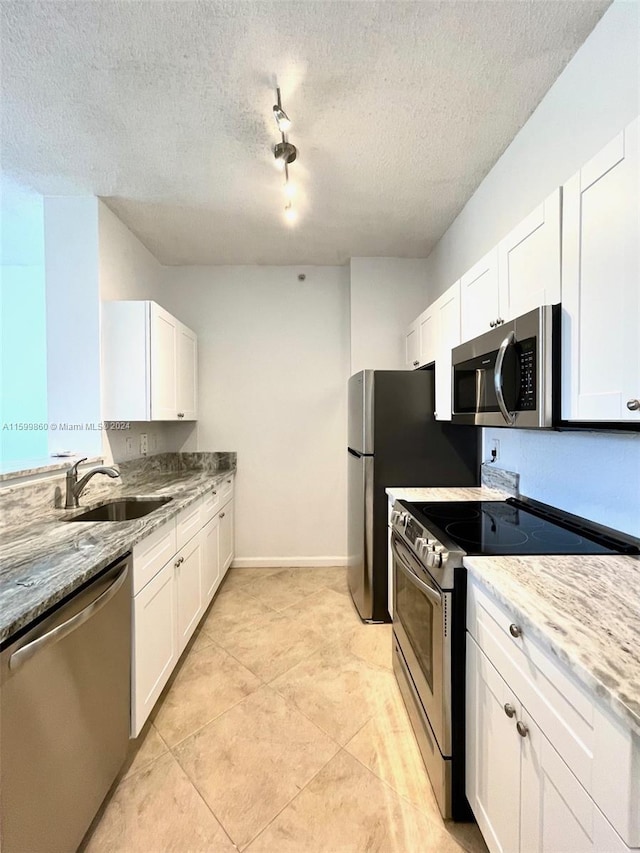 kitchen featuring a textured ceiling, sink, white cabinets, and appliances with stainless steel finishes