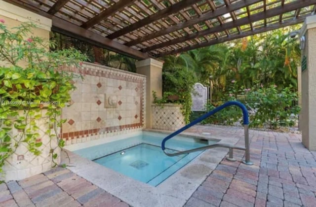 view of pool with a patio area, a pergola, and an in ground hot tub