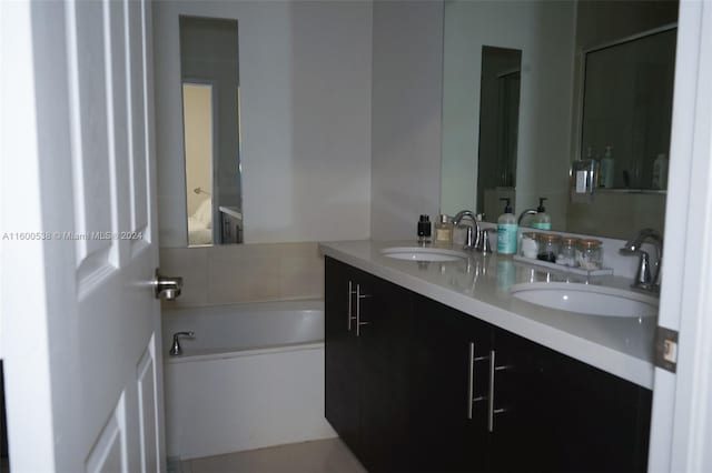 bathroom with double sink, a tub, and vanity with extensive cabinet space