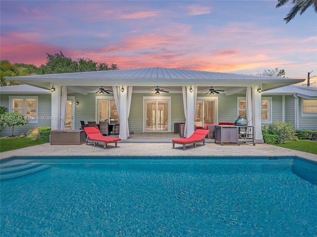 outdoor pool with french doors, a patio area, and ceiling fan