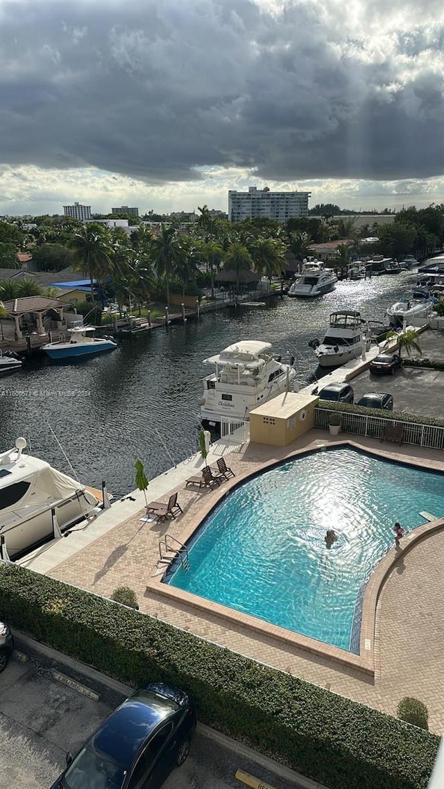 view of pool with a water view and a patio area