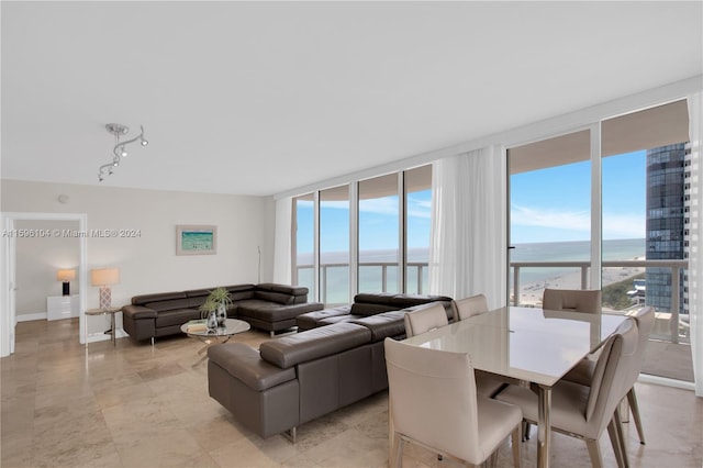 living room with a healthy amount of sunlight, a water view, and floor to ceiling windows