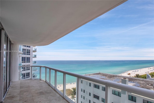 balcony featuring a beach view and a water view