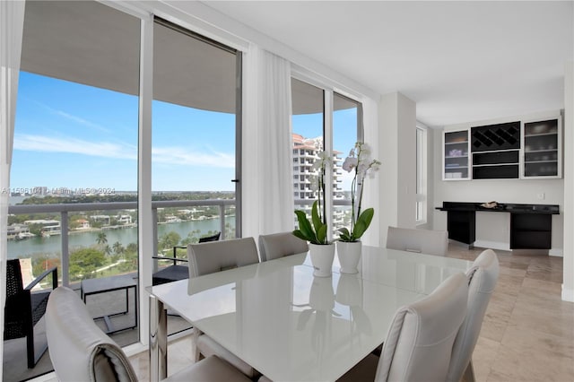 dining area featuring plenty of natural light and a water view