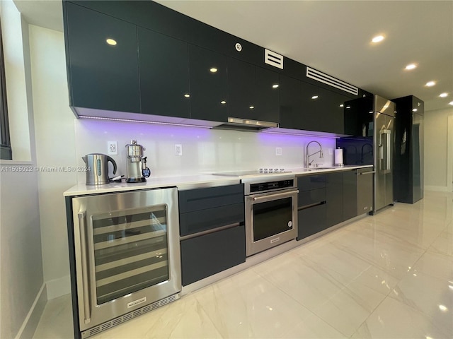 kitchen with sink, wine cooler, range hood, stovetop, and oven