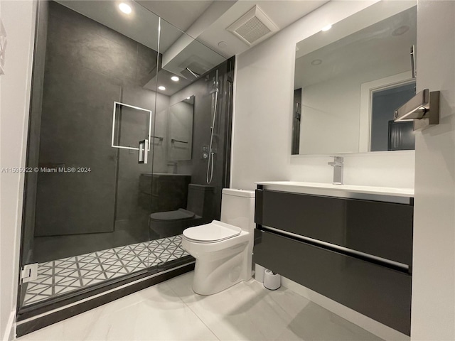 bathroom featuring tile patterned floors, vanity, toilet, and a shower with door