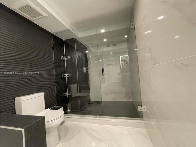 bathroom featuring toilet and an enclosed shower